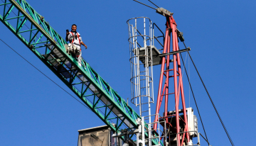 Intentan rescatar a hombre que subió a grúa de construcción