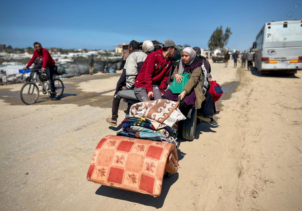 Grupos de ciudadanos palestinos huyen con sus pertenencias.