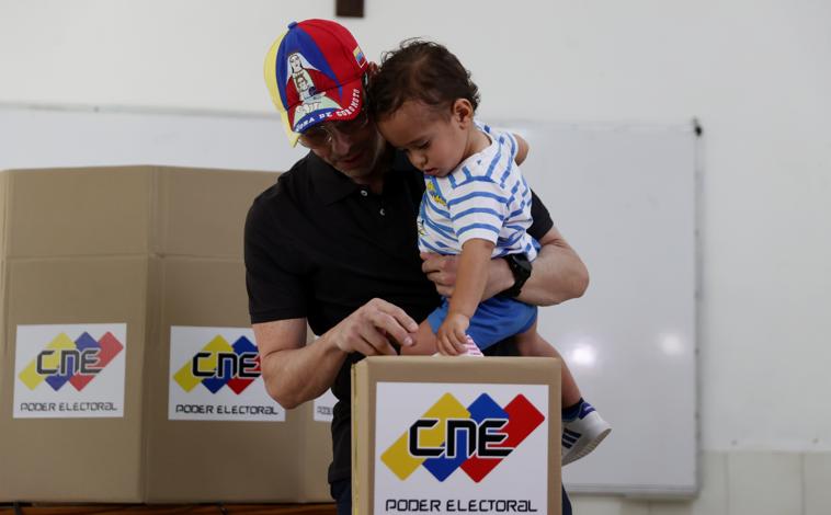 Imagen principal - En la primera foto, el candidato opositor Henrique Capriles ejerce su vot. En la segunda imagen: el candidato oficialista a gobernador de Guayana Esequiba, Neil Villamizar. Un integrante de la Milicia Bolivariana custodia un centro de votación, en la tercera foto