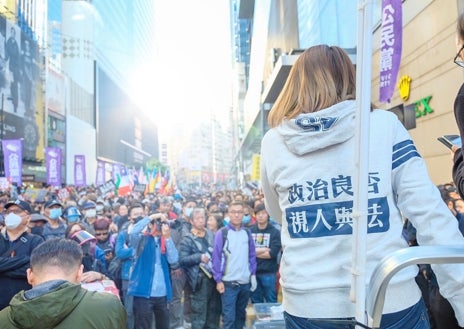 Imagen secundaria 1 - Carmen Lau: «Hay gente en la diáspora y sobre el terreno trabajando para que el movimiento siga adelante». Arriba, Carmen Lau, activista hoy en el exilio, durante las protestas prodemocracia en 2019 en Hong Kong. Abajo, durante la campaña de las elecciones municipales de 2019 y a la derecha, una copia de las cartas remitidas a los vecinos de Carmen Lau, en la que se ofrecía un millón de dólares hongkoneses de recompensa por su entrega a la embajada china