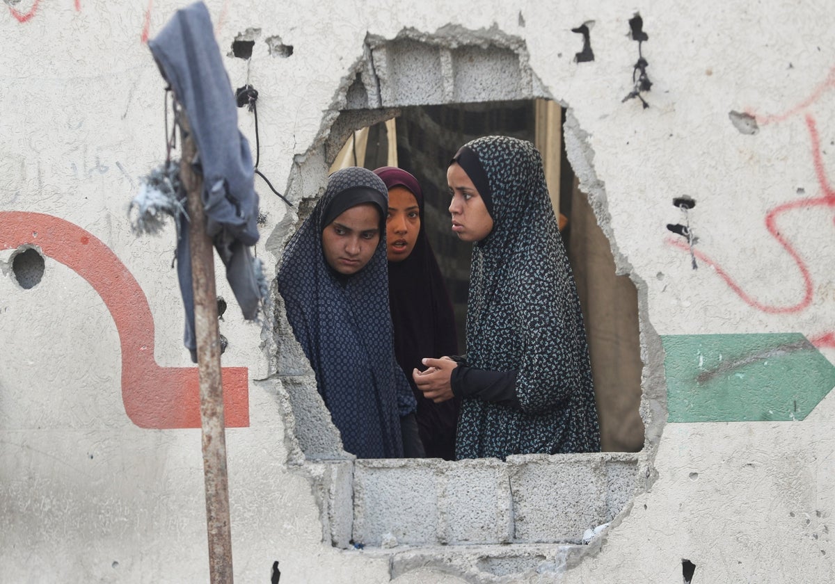 Niñas gazatíes inspeccionan su colegio tras un bombardeo