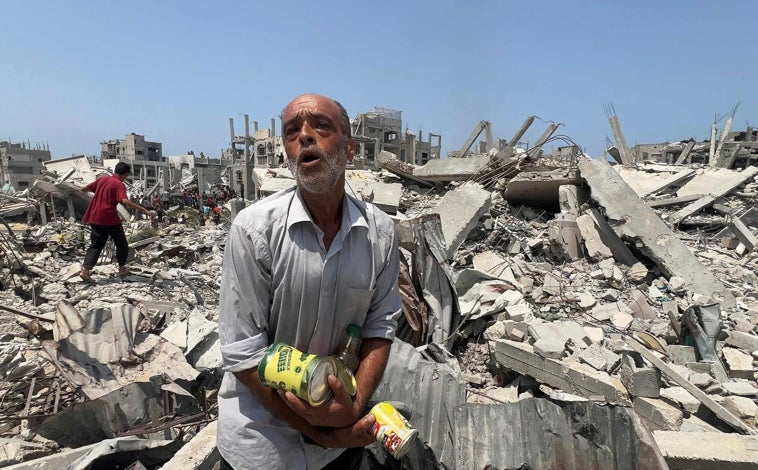 Imagen principal - Palestinos muestran lo que lograron obtener de un paquete de ayuda humanitaria lanzado por un avión militar en Jabalia, en el norte de la Franja
