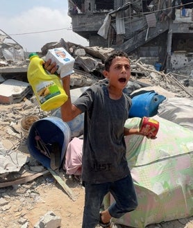 Imagen secundaria 2 - Palestinos muestran lo que lograron obtener de un paquete de ayuda humanitaria lanzado por un avión militar en Jabalia, en el norte de la Franja