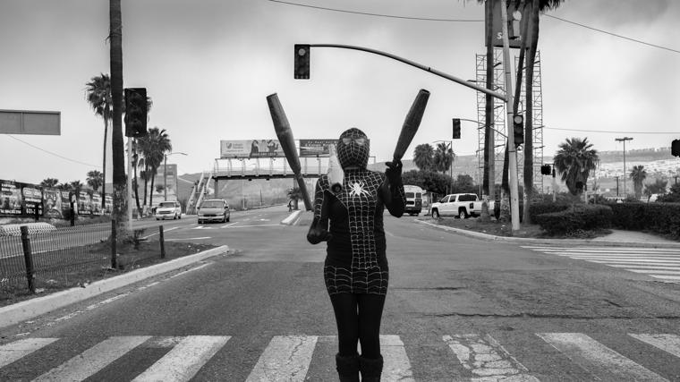 Claudia trabaja como artista callejera en uno de los semáforos de la ciudad, buscando ingresos en el espacio público. Durante años, Tijuana ha sido refugio y punto de paso para inmigrantes y deportados que no lograron alcanzar su sueño americano