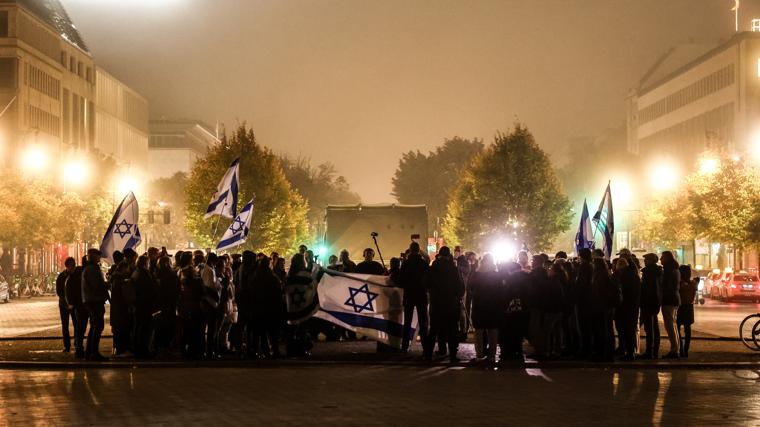 En Berlín, un grupo de personas lleva banderas de Israel en homenaje a las víctimas del 7-O