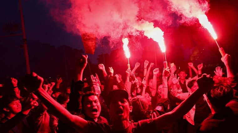 Estudiantes universitarios encienden bengalas durante una protesta en el primer aniversario del gobierno del presidente indonesio Prabowo Subianto