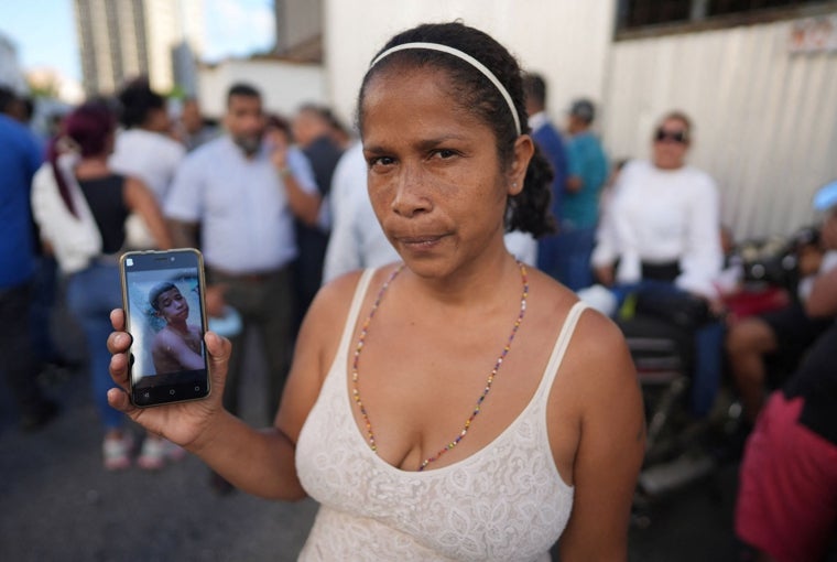 Una madre muestra la foto de su hijo, de 18 años, detenido durante las protestas poselectorales en Venezuela