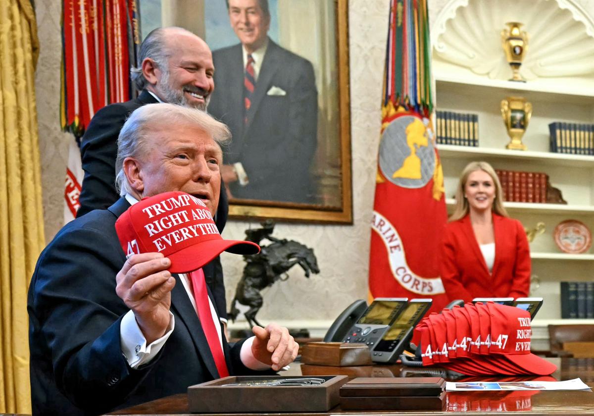 El presidente de EE.UU., en el Despacho Oval, sostiene una gorra que dice 'Trump tenía razón sobre todo'