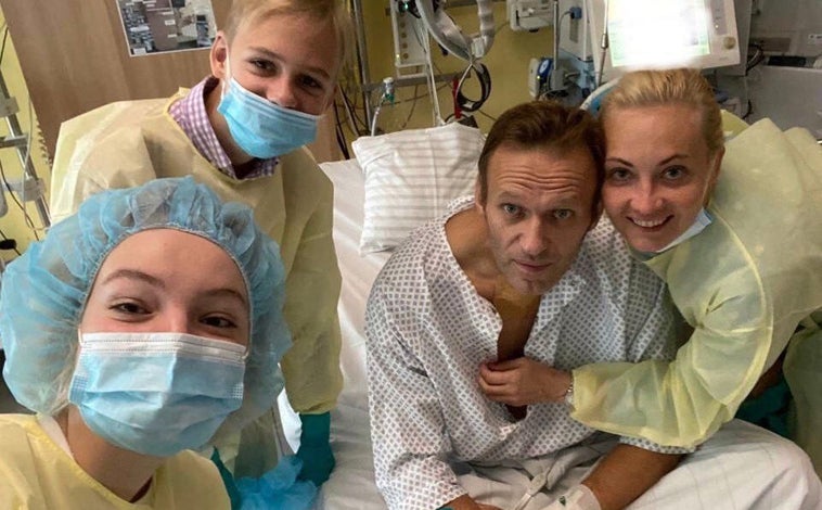 Imagen principal - Arriba, el opositor ruso con su esposa, Yulia Navalnaya, y sus dos hijos en el hospital de la Charité de Berlín, donde fue ingresado tras el envenenamiento que sufrió en Siberia; debajo, en el avión de regreso a Moscú el 17 de enero de 2012; a la derecha, una joven llora ante la tumba de Navalni, en el cementerio Borísov de Moscú, el 2 de marzo de 2024, un día después de su entierro