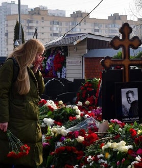 Imagen secundaria 2 - Arriba, el opositor ruso con su esposa, Yulia Navalnaya, y sus dos hijos en el hospital de la Charité de Berlín, donde fue ingresado tras el envenenamiento que sufrió en Siberia; debajo, en el avión de regreso a Moscú el 17 de enero de 2012; a la derecha, una joven llora ante la tumba de Navalni, en el cementerio Borísov de Moscú, el 2 de marzo de 2024, un día después de su entierro