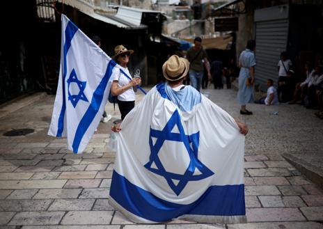 Imagen secundaria 1 - En la primera foto, Israelíes de derecha se reúnen cerca de la Puerta de Damasco durante la 'Marcha de la Bandera' israelí en la Ciudad Vieja de Jerusalén. Un israelí porta una bandera del país en el Día de Jerusalén, en la segunda imagen. Tercera foto: la policía retira a un activista israelí de derecha en la Ciudad Vieja de Jerusalén durante una marcha de banderas por el Día de Jerusalén.