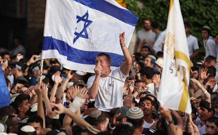 Imagen principal - En la primera foto, Israelíes de derecha se reúnen cerca de la Puerta de Damasco durante la 'Marcha de la Bandera' israelí en la Ciudad Vieja de Jerusalén. Un israelí porta una bandera del país en el Día de Jerusalén, en la segunda imagen. Tercera foto: la policía retira a un activista israelí de derecha en la Ciudad Vieja de Jerusalén durante una marcha de banderas por el Día de Jerusalén.