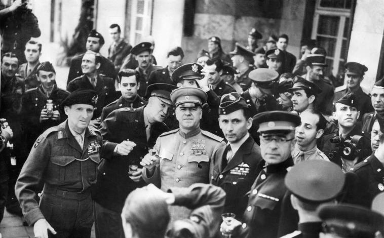 Imagen principal - Los mariscales británico y soviétocos, Montgomery, Zhukov y Tedder, junto al general Eisenhower brindando en Fráncfort tras la firma de la rendición alemana en Reims, en la primera imagen. Segunda foto: Churchill en el frente, visitando la linea Siegfried. En la tercera imagen, un soldado soviético observa el edificio del Reichstag destruido