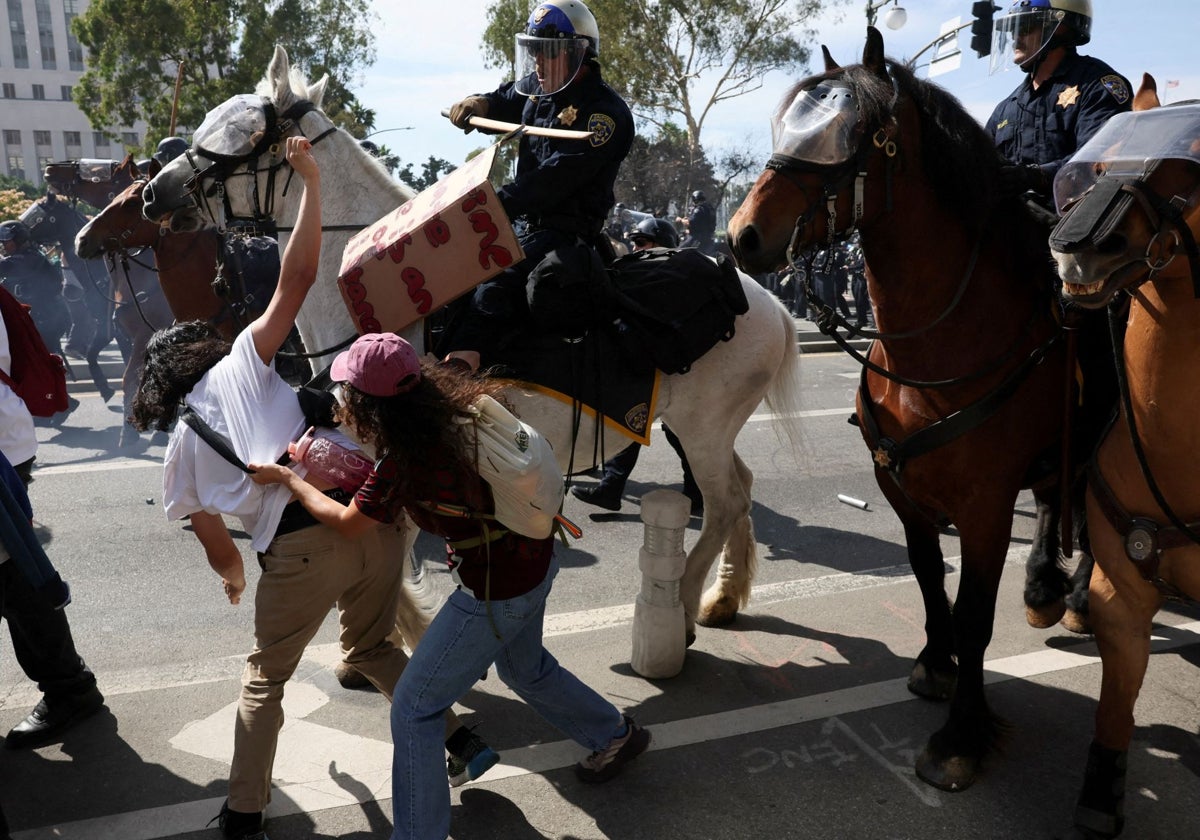 Agentes de la policía montada dispersan a los manifestantes en Los Ángeles durante una protesta contra las políticas de Trump