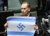 Un diputado polaco de derecha radical muestra en el parlamento la bandera israelí con la esvástica nazi