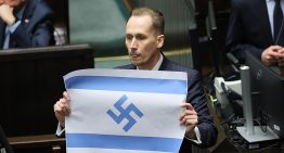 Un diputado polaco de derecha radical muestra en el parlamento la bandera israelí con la esvástica nazi