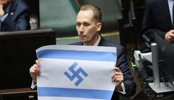 Un diputado polaco de derecha radical muestra en el parlamento la bandera israelí con la esvástica nazi