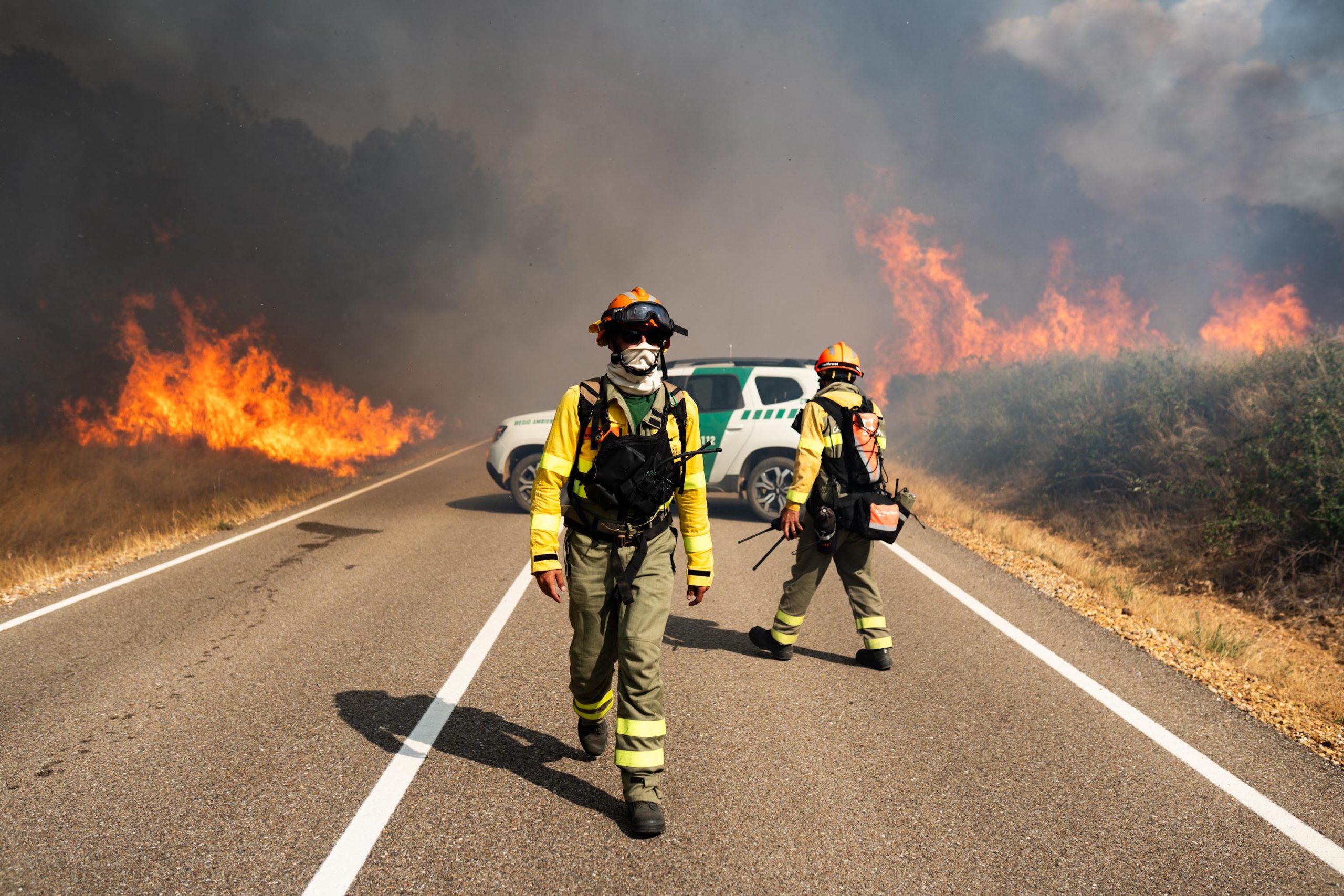 Dos bomberos luchan contra el fuego en las inmediaciones de Molezuelas de la Carballeda, Zamora. 