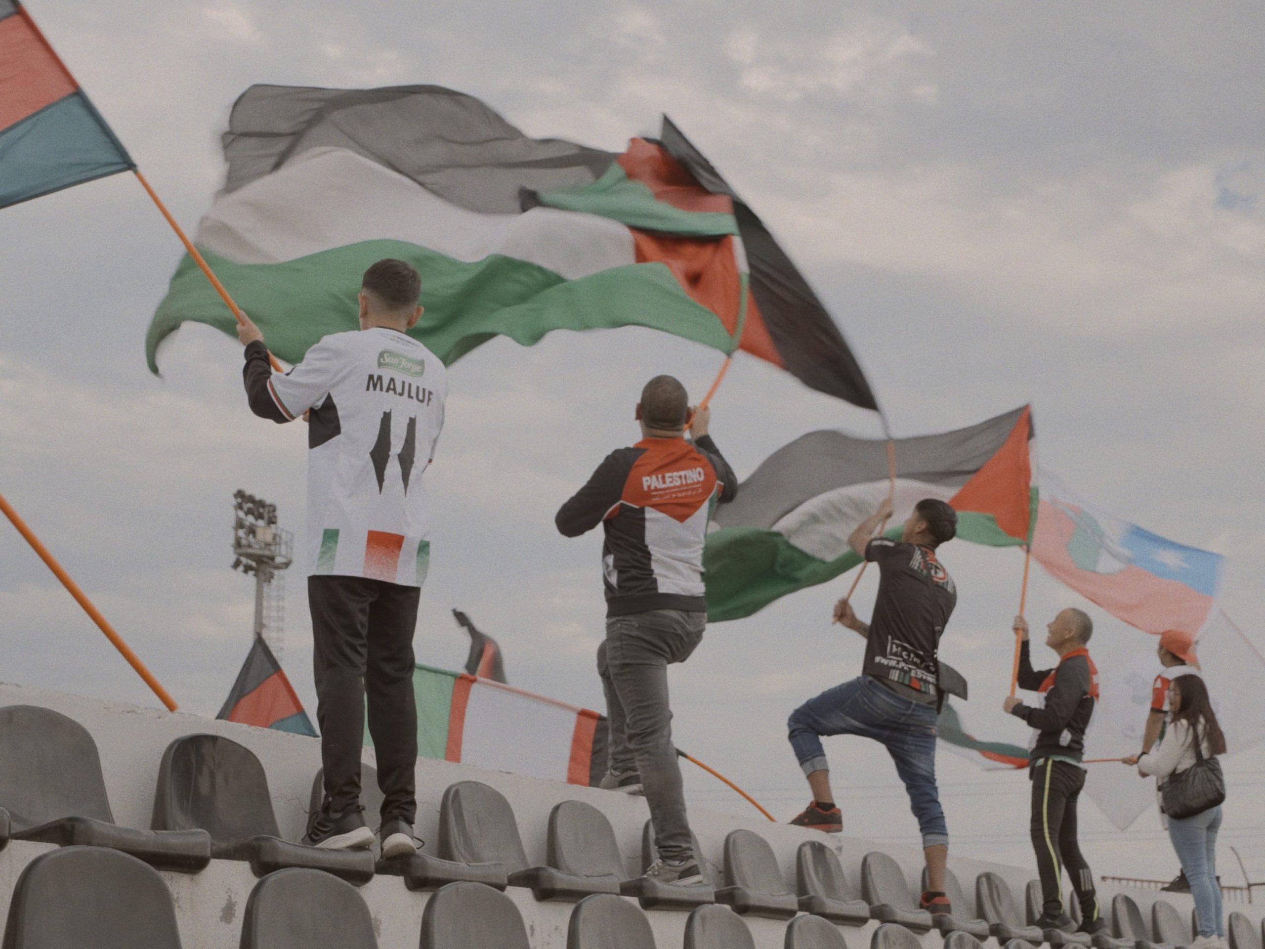Miembros de la barra brava del Club Deportivo Palestino en las gradas del estadio municipal de La Cisterna, en un fotograma de 'Baisanos'.