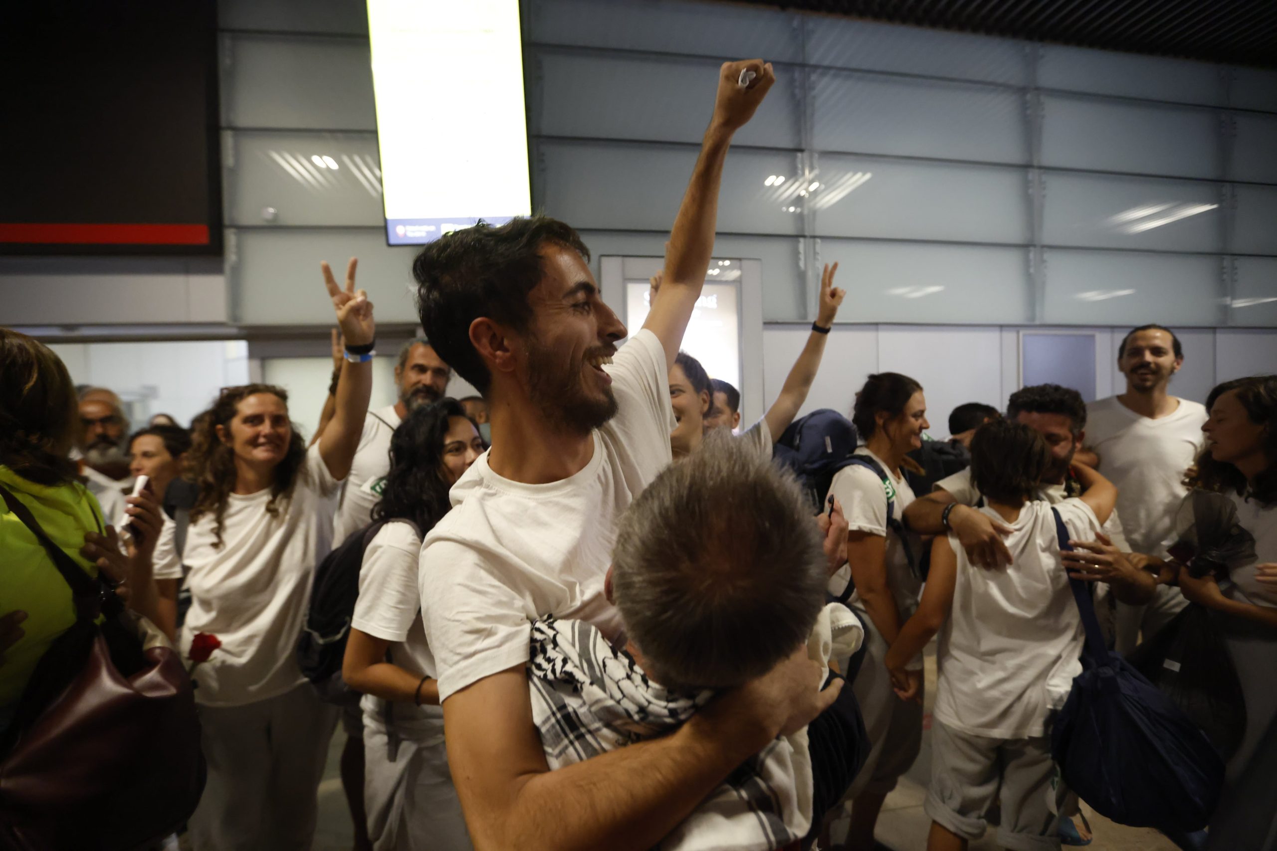 Los españoles deportados por Israel se abrazan a sus familiares y amigos este domingo en el aeropuerto de Madrid-Barajas.