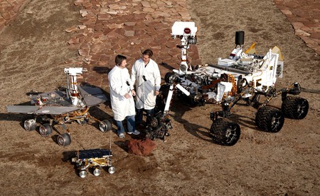 Ingenieros de la NASA junto a maquetas de Sojourner, Opportunity y Curiosity