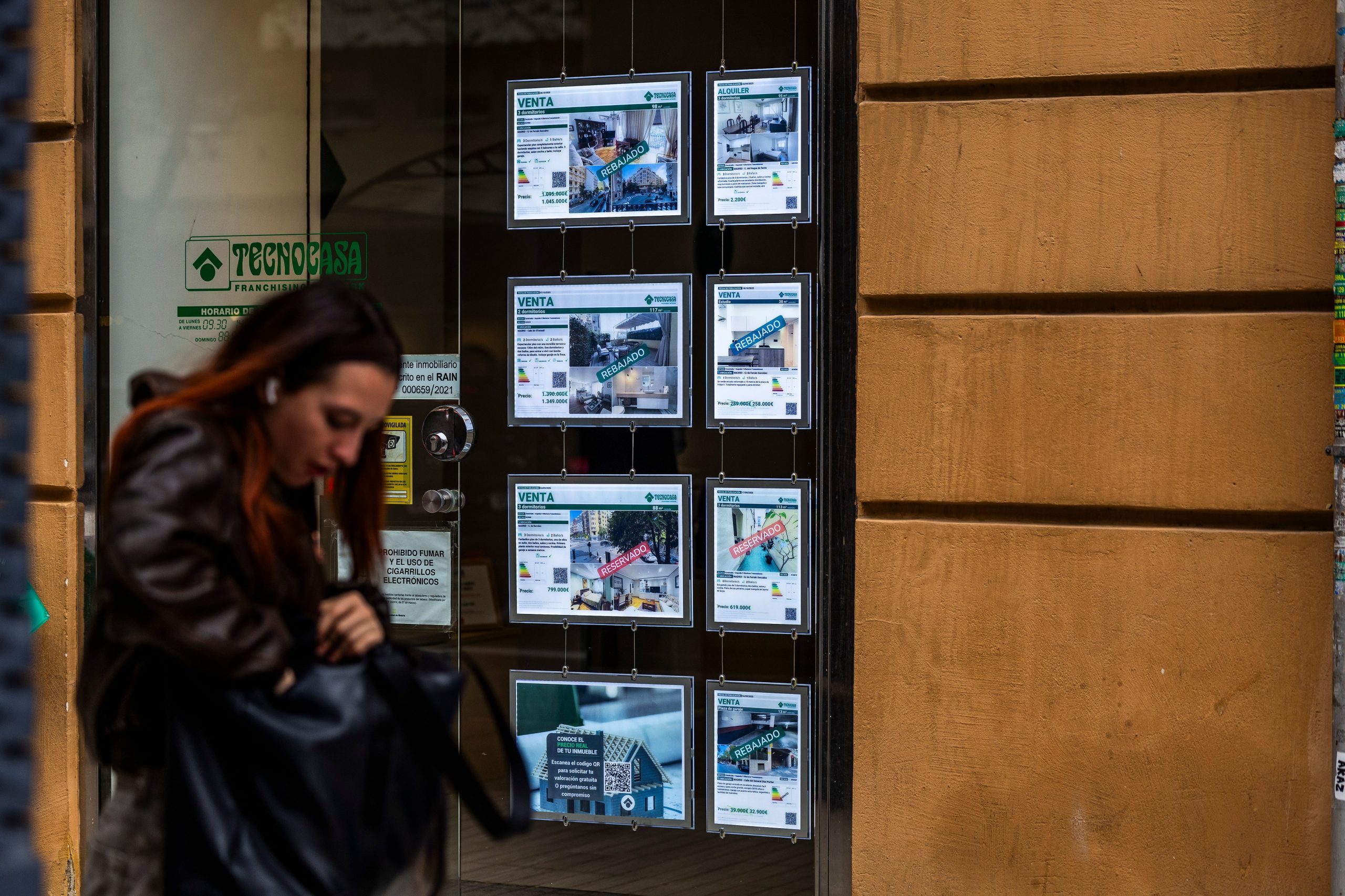 Una mujer pasa frente a una inmobiliaria, en Madrid.