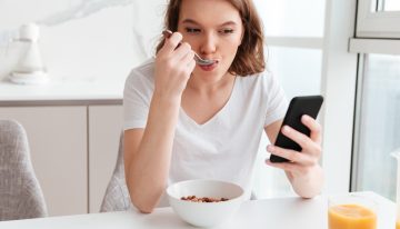Creíamos que comer con el móvil en la mano era inofensivo. La ciencia avisa de que está «hackeando» nuestra saciedad