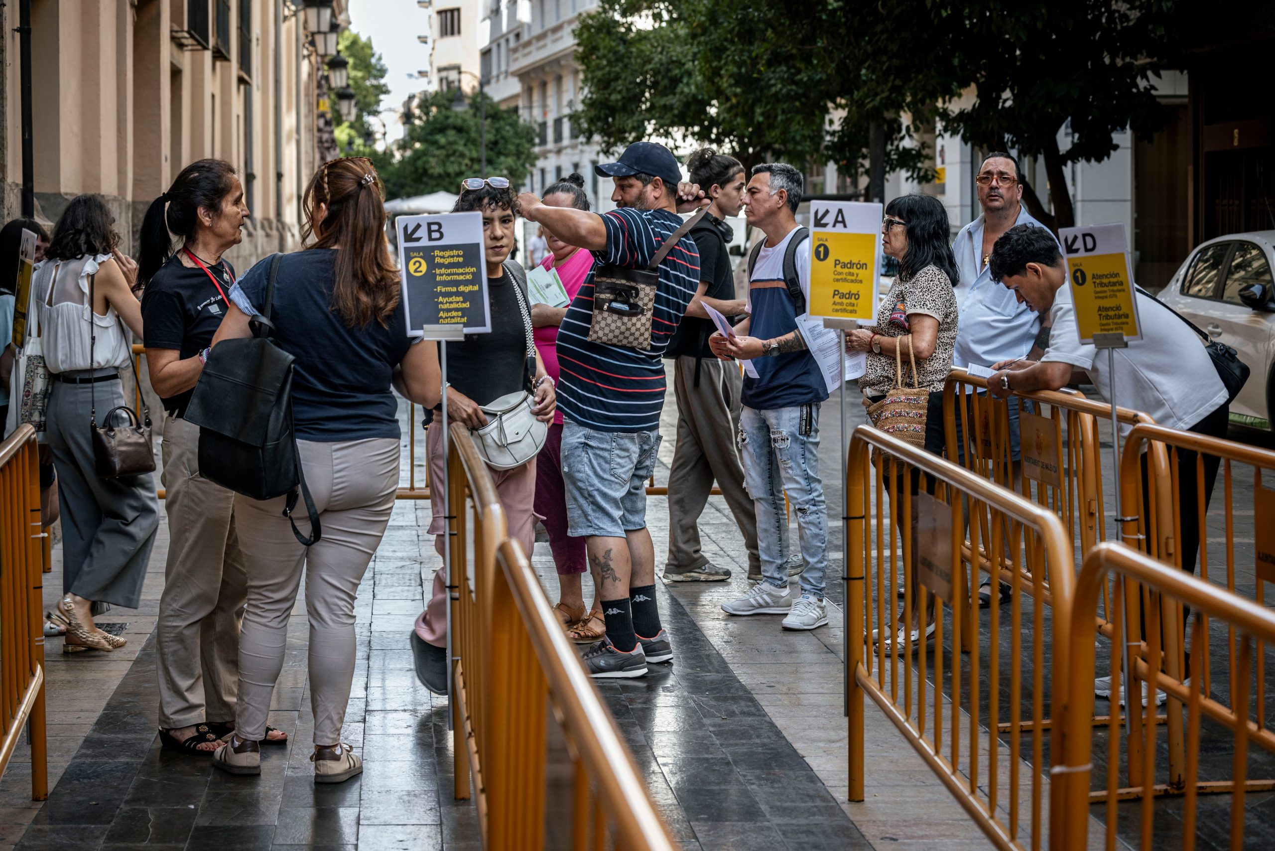 Varios inmigrantes hacen cola en el Ayuntamiento de Valencia para iniciar el proceso de regularización extraordinario el lunes.