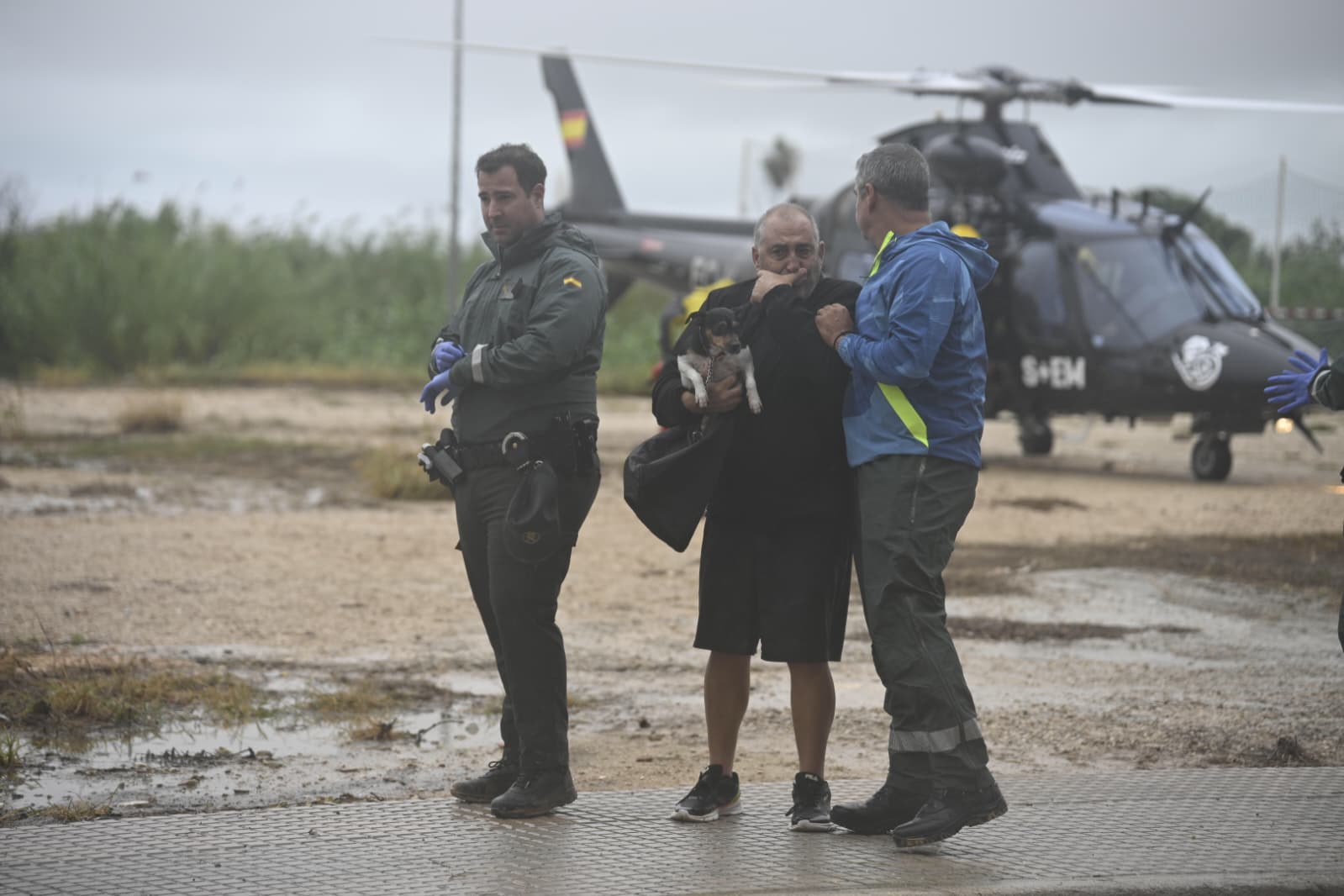 Dos agentes de la Guardia Civil, con un hombre tras rescatarlo de las inundaciones en Oliva (Valencia).