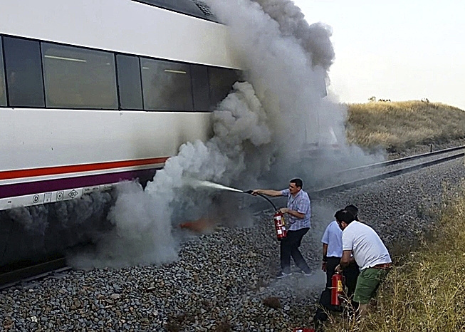 Pasajeros tratan de apagar un tren en llamas.