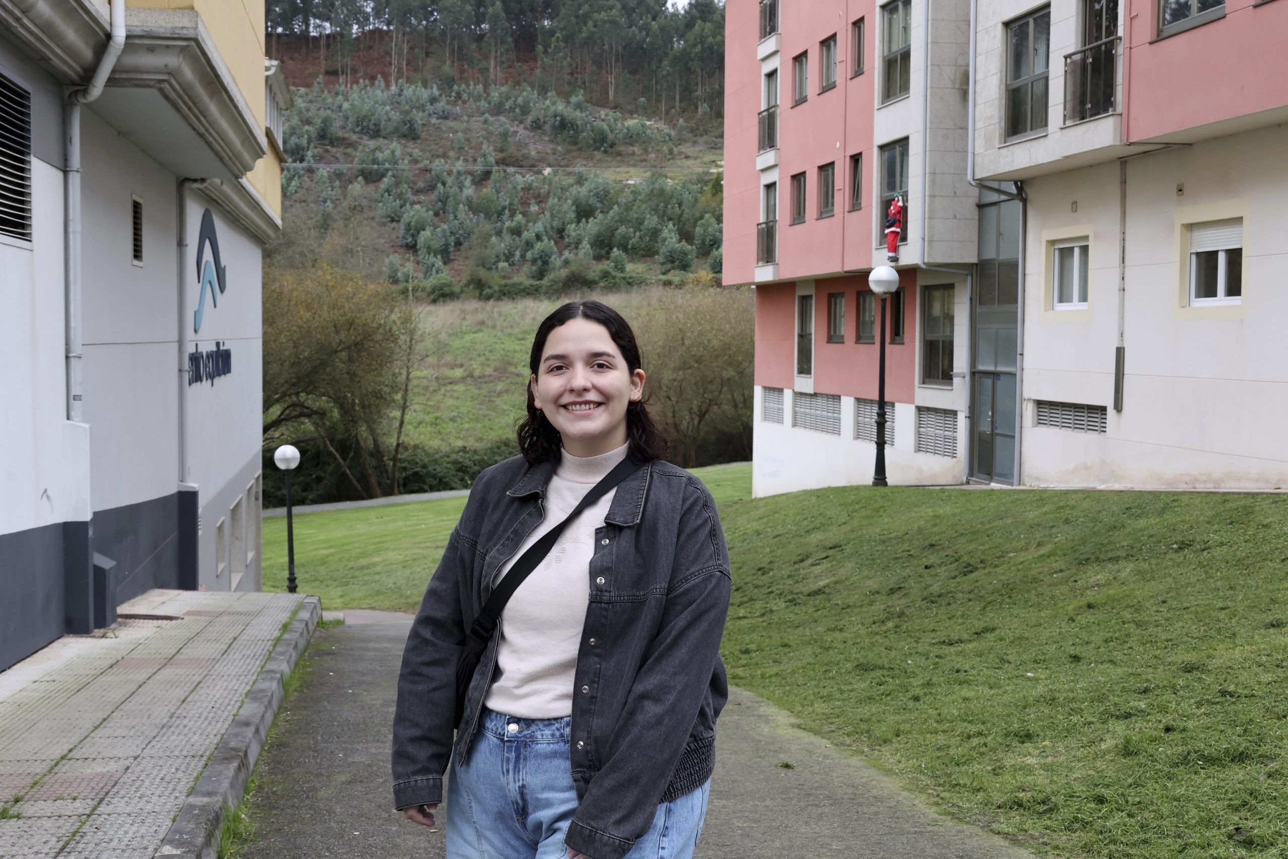 Lourdes posa frente a la empresa en la que trabaja como operaria de limpieza, en Arteixo.