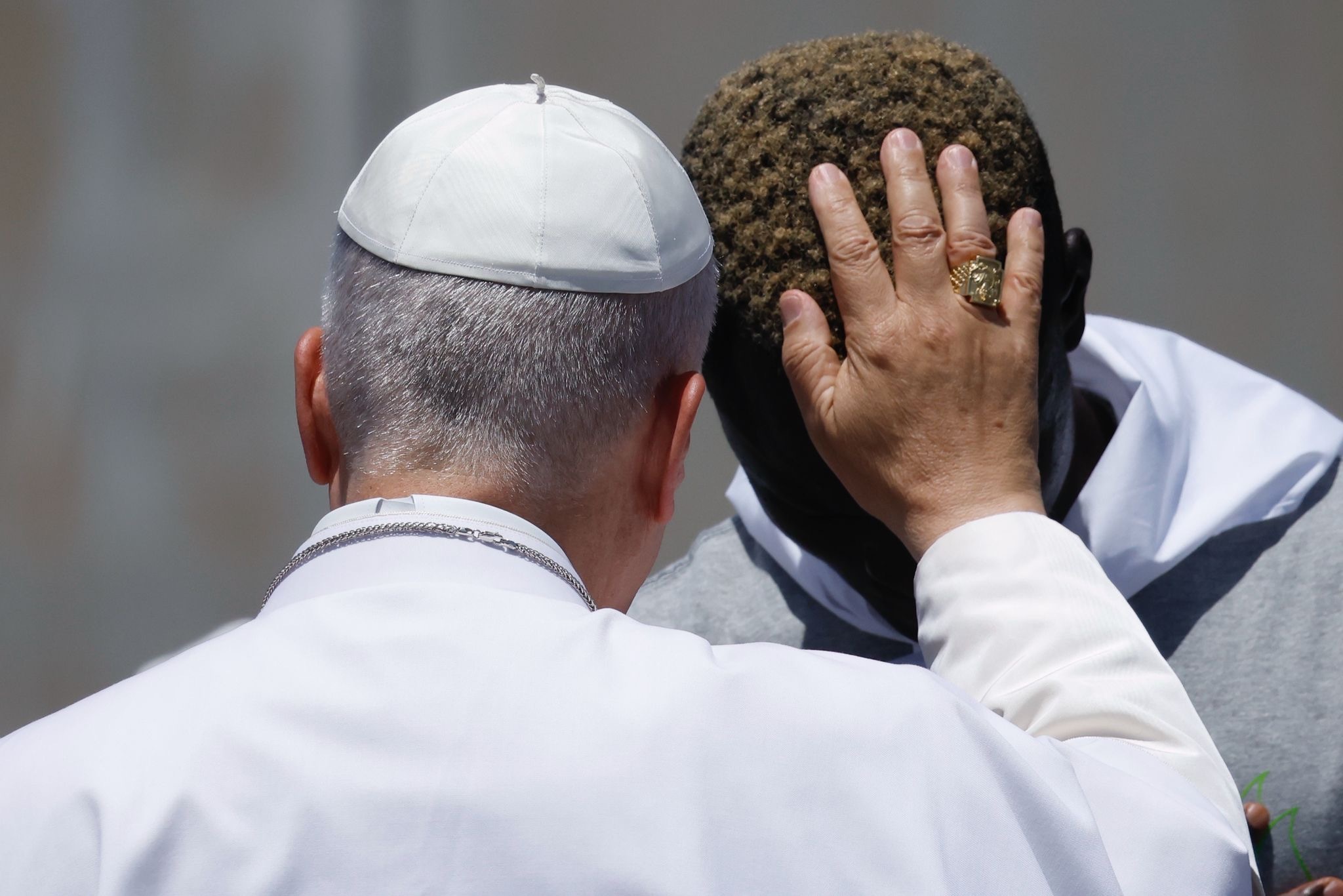 El Papa bendice a uno de los migrantes que le acompañó en el momento de lanzar la ofrenda de flores al mar