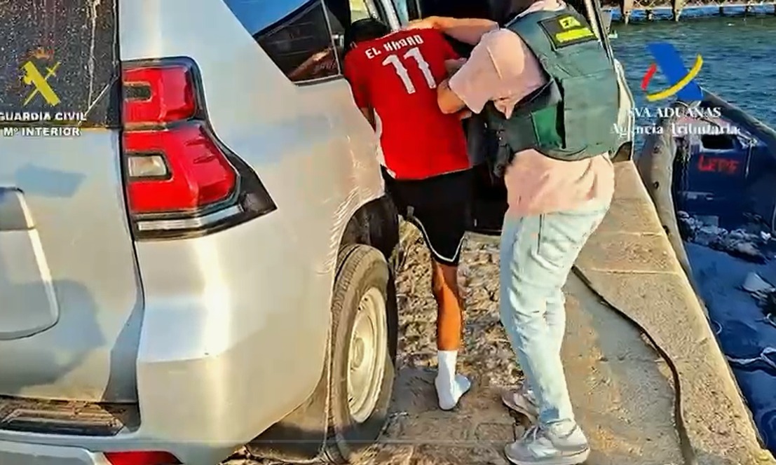 Un agente, con uno de los detenidos.