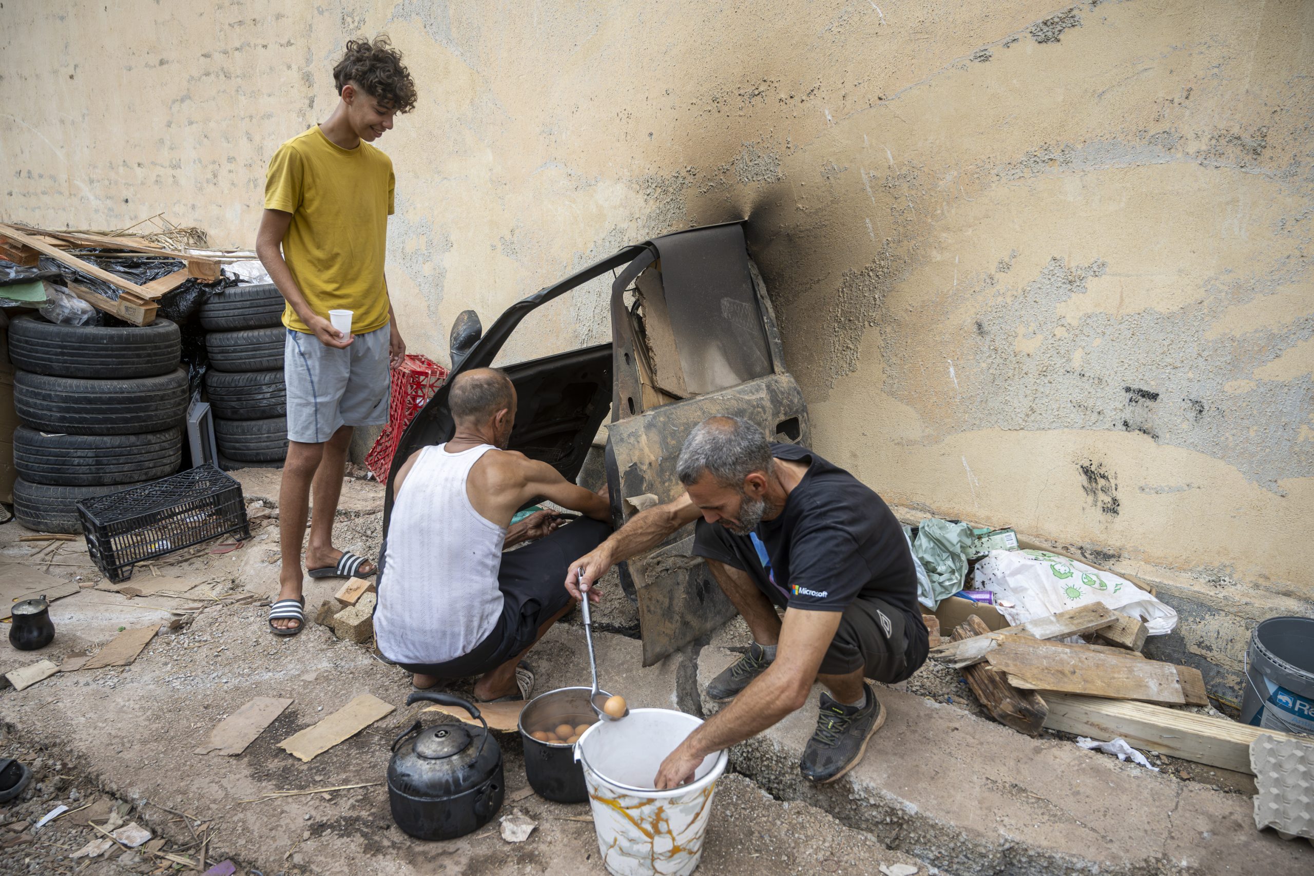 Adam (19) observa a su padre, Mohami (51) preparar la comida del campamento.