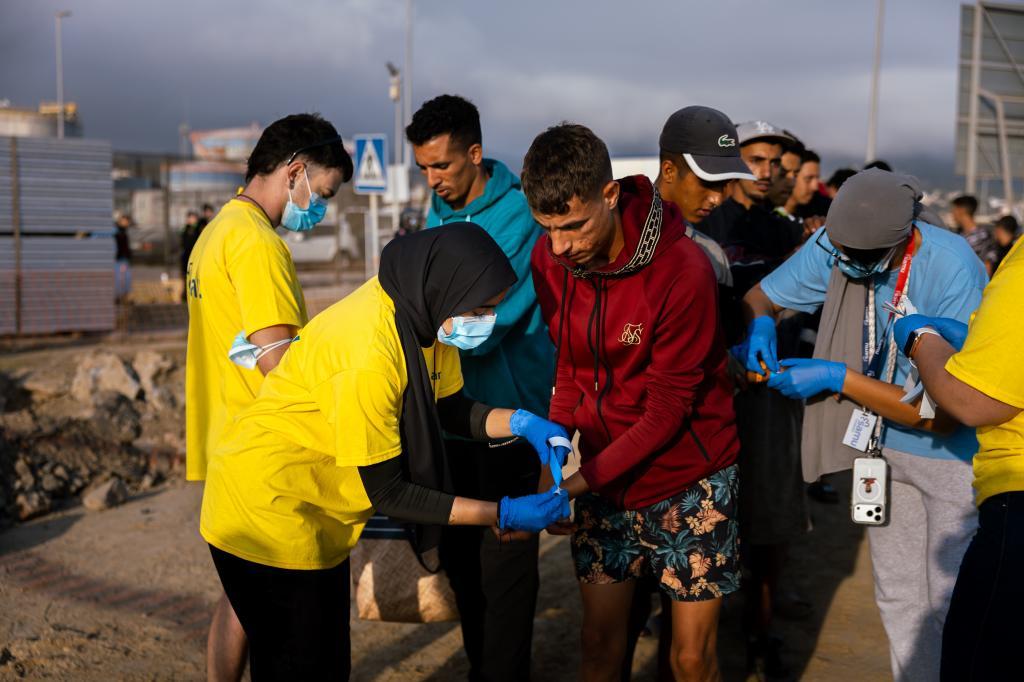 Personal del campamento del puerto colocan pulseras a los magrebíes que han logrado acceder a las instalaciones.