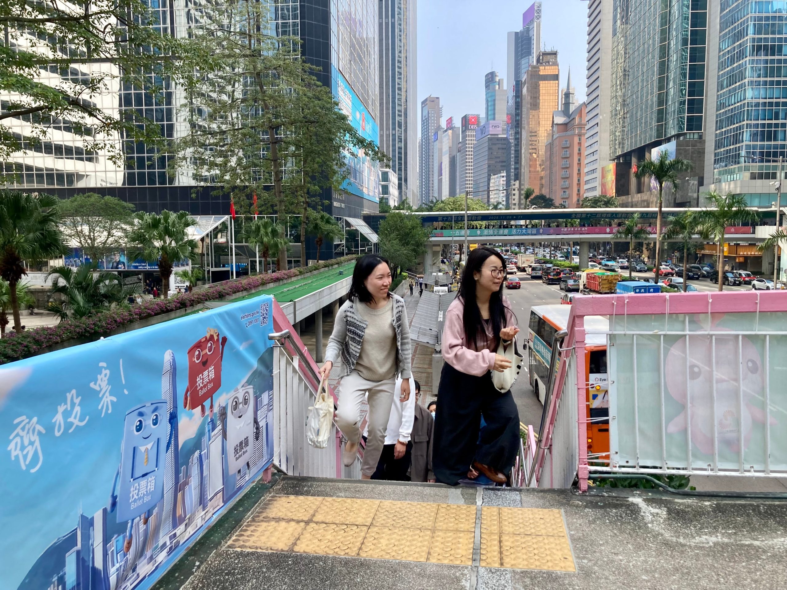Un grupo de personas pasa junto a publicidad que anima a votar en Hong Kong, el viernes 5 de diciembre.
