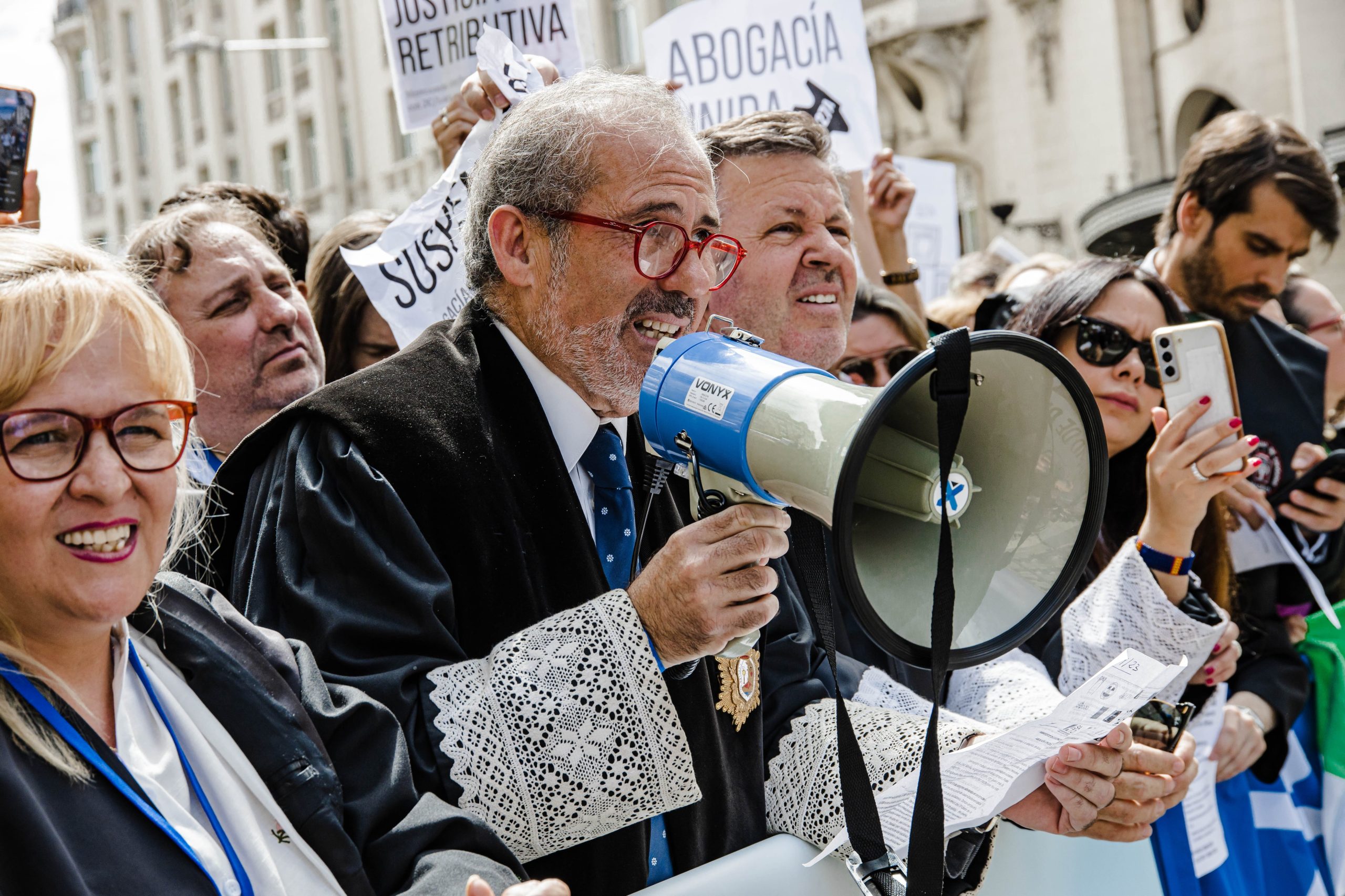 El decano emérito del Colegio de Abogados de Málaga, José Francisco Lara Peláez, sujeta un megáfono durante una protesta para reclamar mejoras laborales