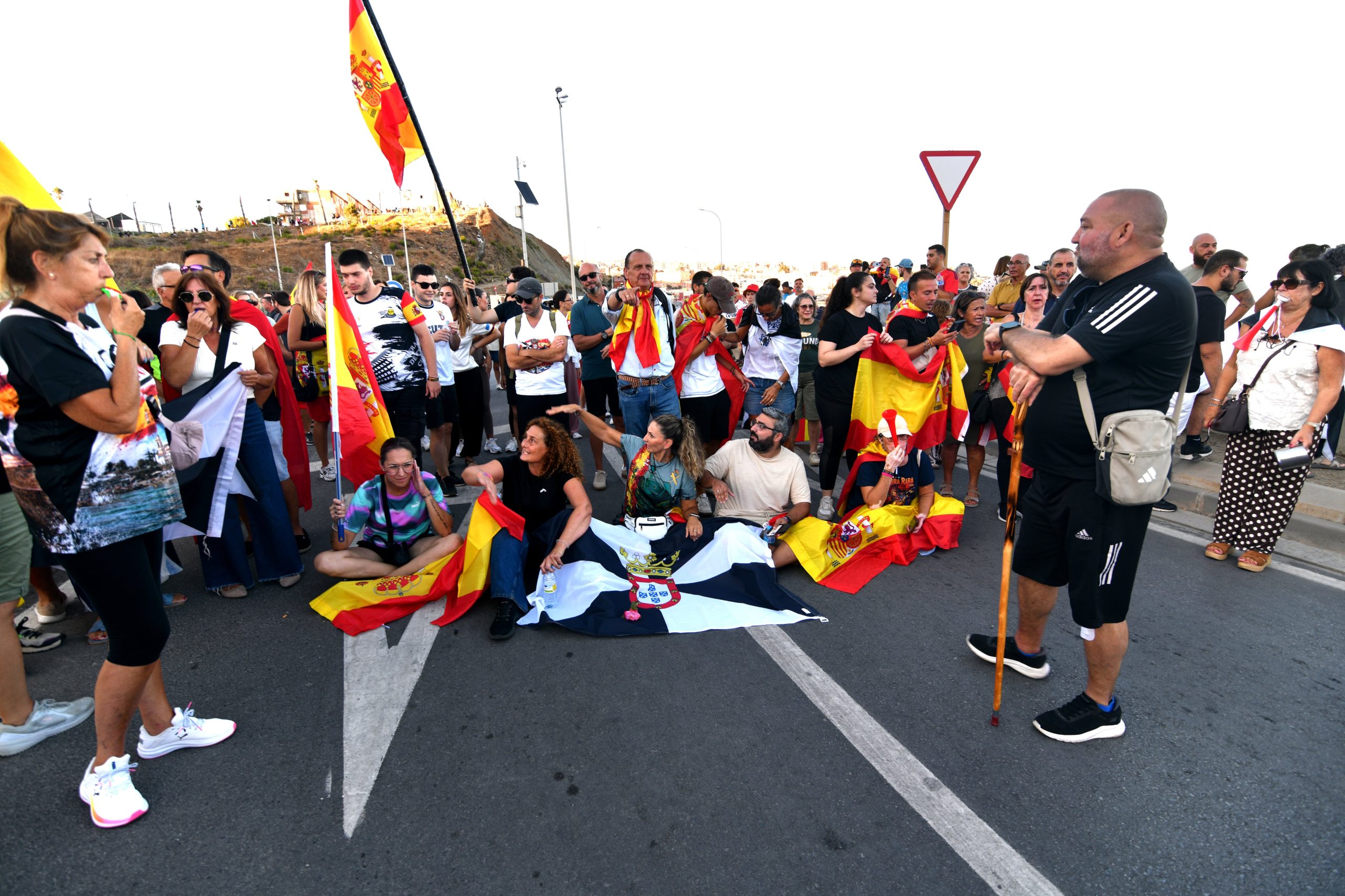 Un grupo de manifestantes se sienta durante una marcha por la crisis migratoria este sábado en Ceuta.