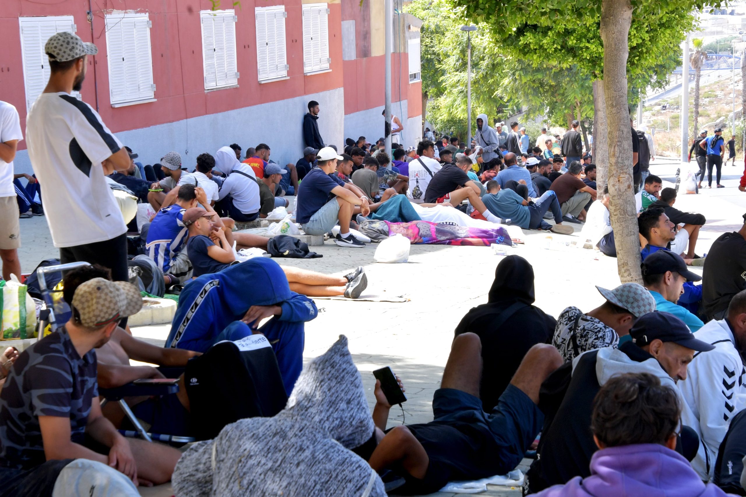Varios cientos de personas se concentran en los alrededores de Loma Colmenar esperando para poder entrar en el campamento, en Ceuta este sábado. 