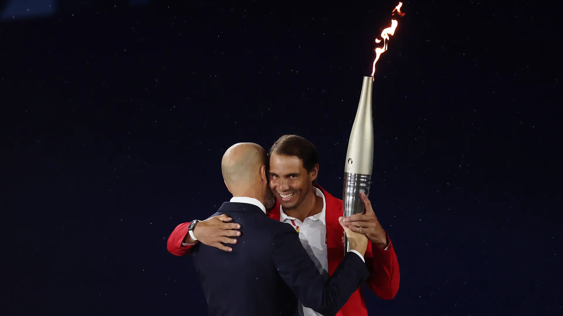 La imagen de la ceremonia inaugural de los Juegos: Rafa Nadal recibe la antorcha olímpica de manos de Zinedine Zidane