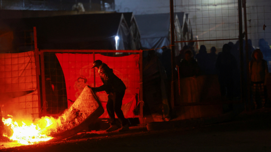 Un migrante quema sus pertenencias durante una operación llevada a cabo por las autoridades mexicanas para desalojar a migrantes de un campamento improvisado, en Chihuahua, estado de Chihuahua.