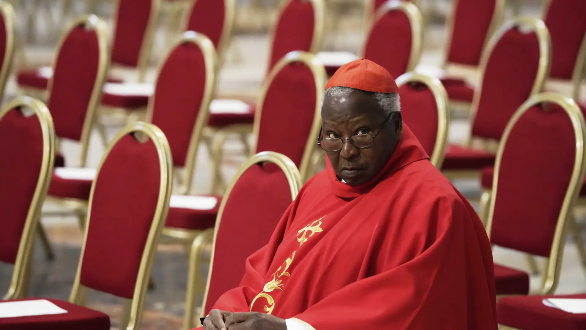 El cardenal de Kenia asegura que no acudirá al cónclave porque no recibió invitación, pero el Vaticano le recuerda que no la necesita