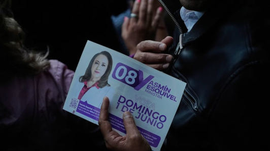 Un partidario de Yasmin Esquivel, candidata a la Corte Suprema de México, sostiene un folleto de campaña en el mitin de cierre de su campaña en Ciudad de México. Foto: AP