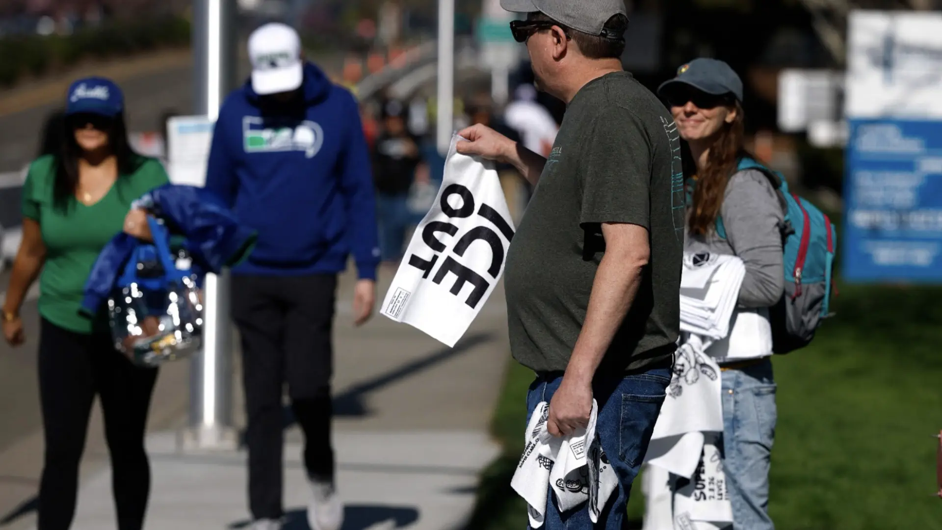 Activistas reparten toallas con el lema de 'ICE fuera' a los aficionados que asisten del Super Bowl