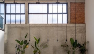 Una antigua fábrica de aceite de la Toscana se transforma en una casa de estética industrial protagoniza por el hormigón y un horno para pizzas en el patio privado