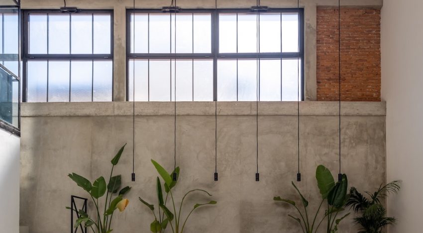 Una antigua fábrica de aceite de la Toscana se transforma en una casa de estética industrial protagoniza por el hormigón y un horno para pizzas en el patio privado